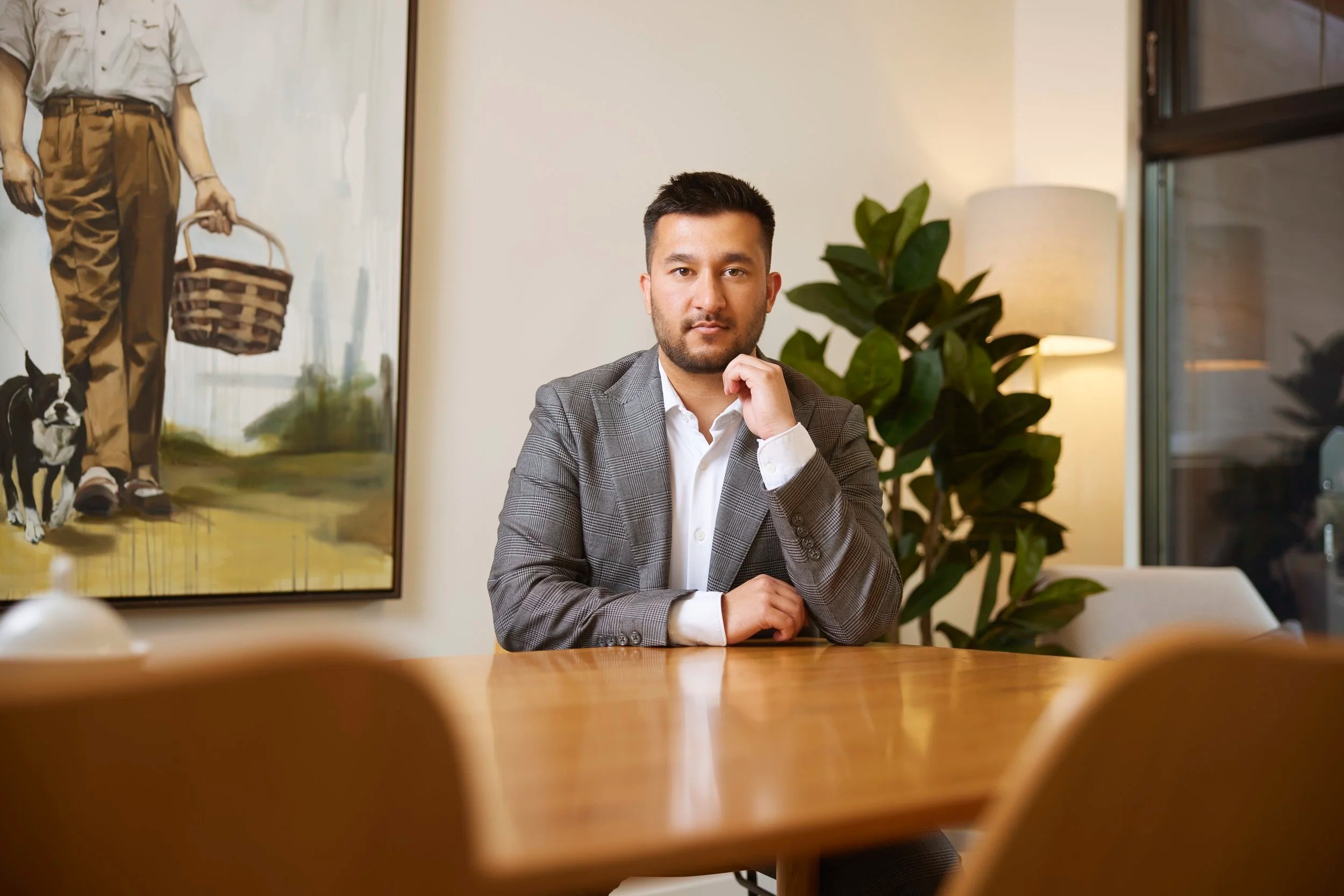 Office portrait at a meeting table, a painting behind
