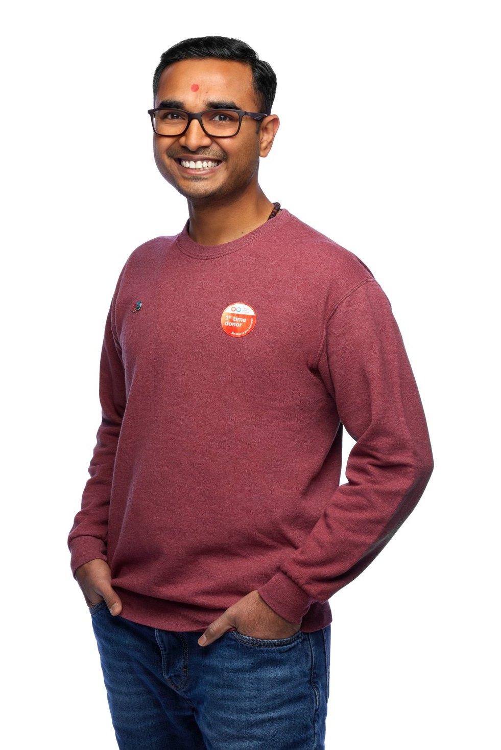 A man in a maroon sweatshirt, hands in his pockets