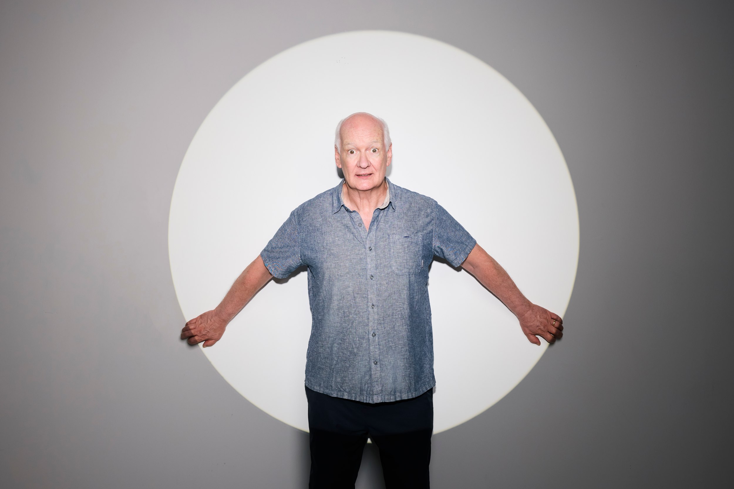 Standing in the circle of light, arms held out to its edges