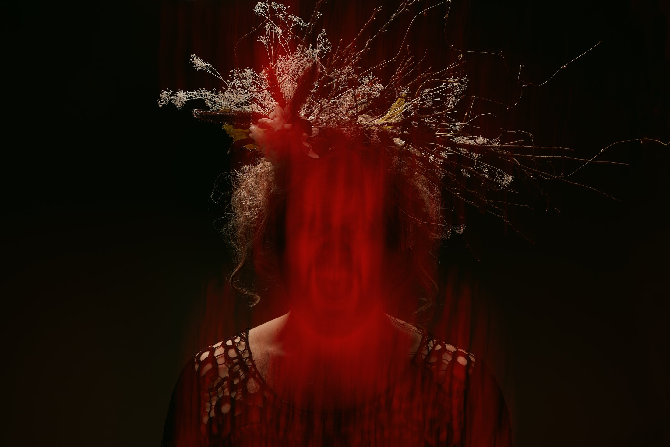 Macbeth promo, a multiple exposure in red light: a figure’s hair thrown across the frame against black