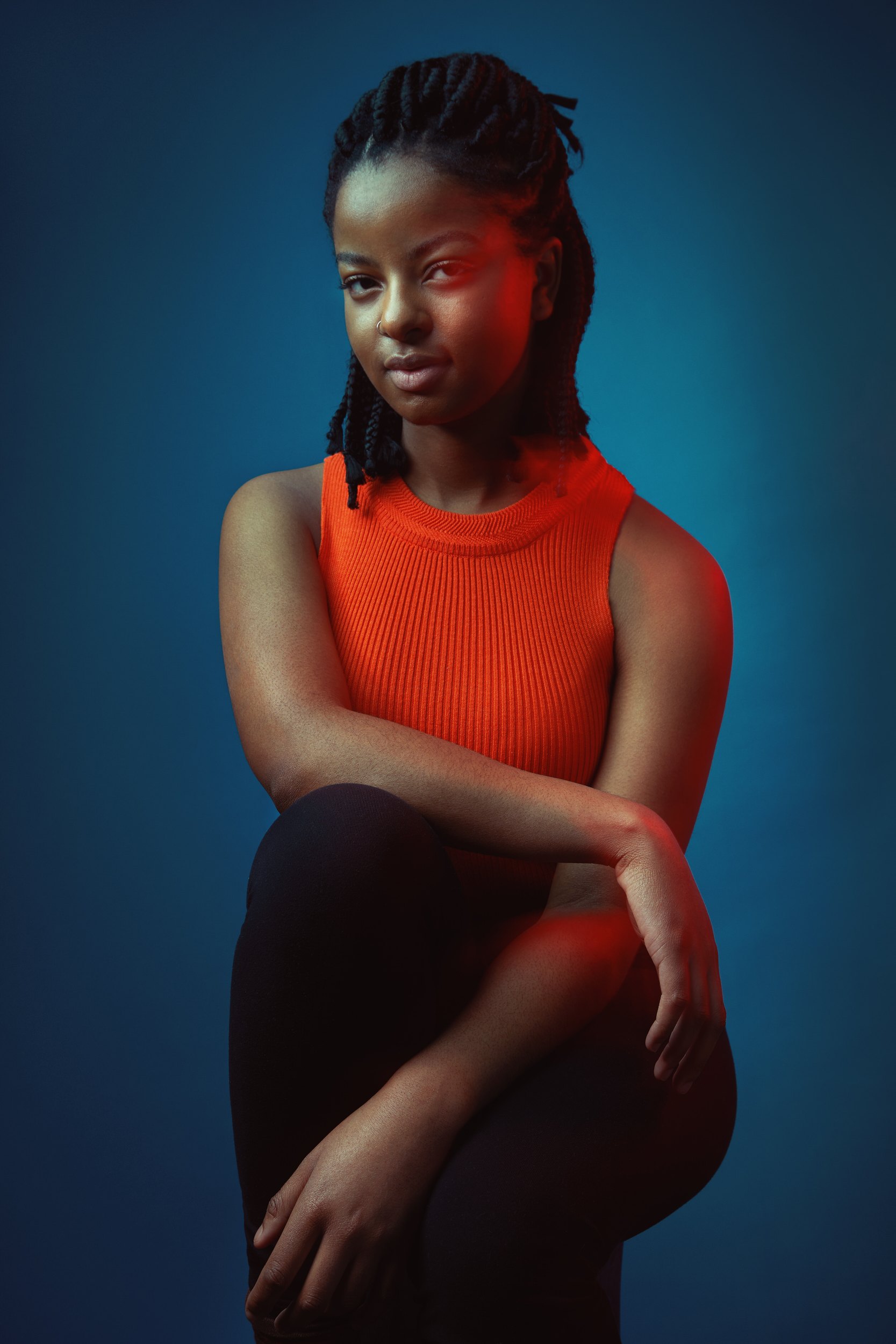 The same session, seated in an orange top under red and blue gels