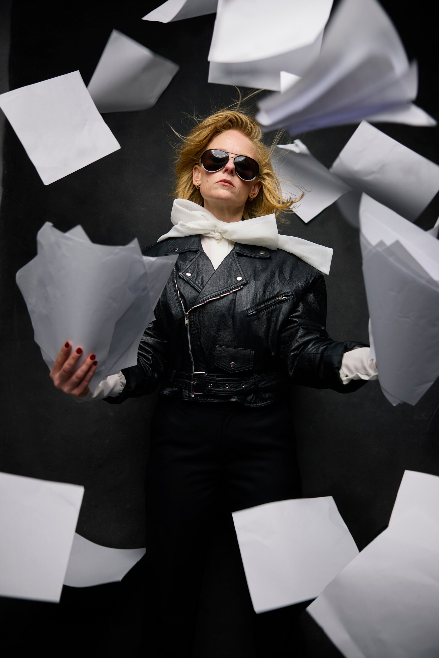 The same session, sheets of paper thrown in the air around her, white gloves on