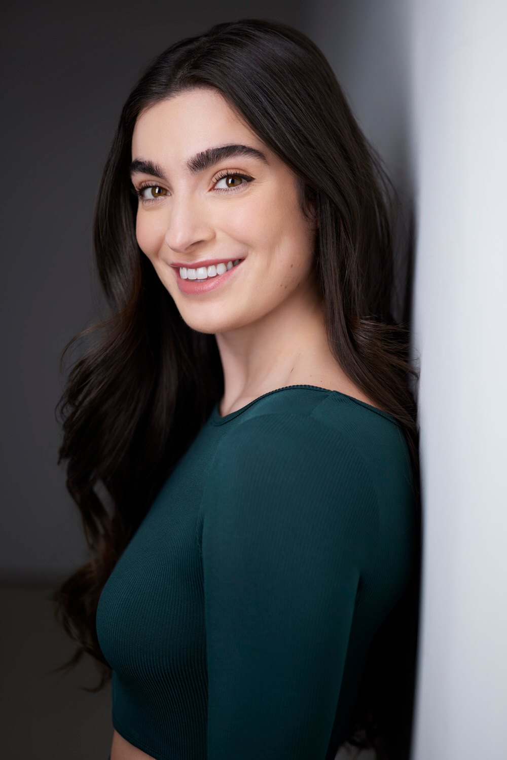 Dance headshot: a green top against the wall of light