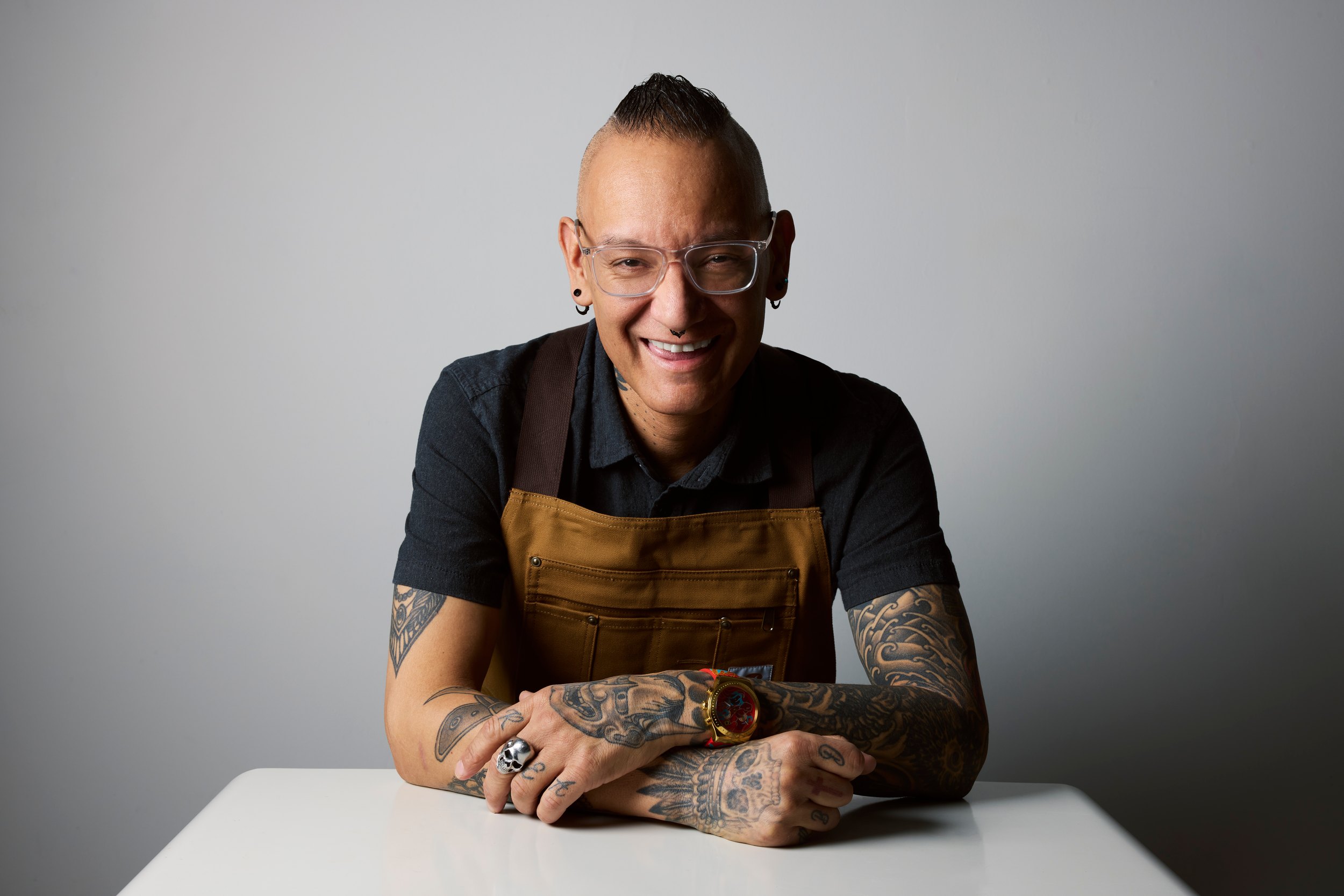 Standing beside it, an apron over a dark shirt