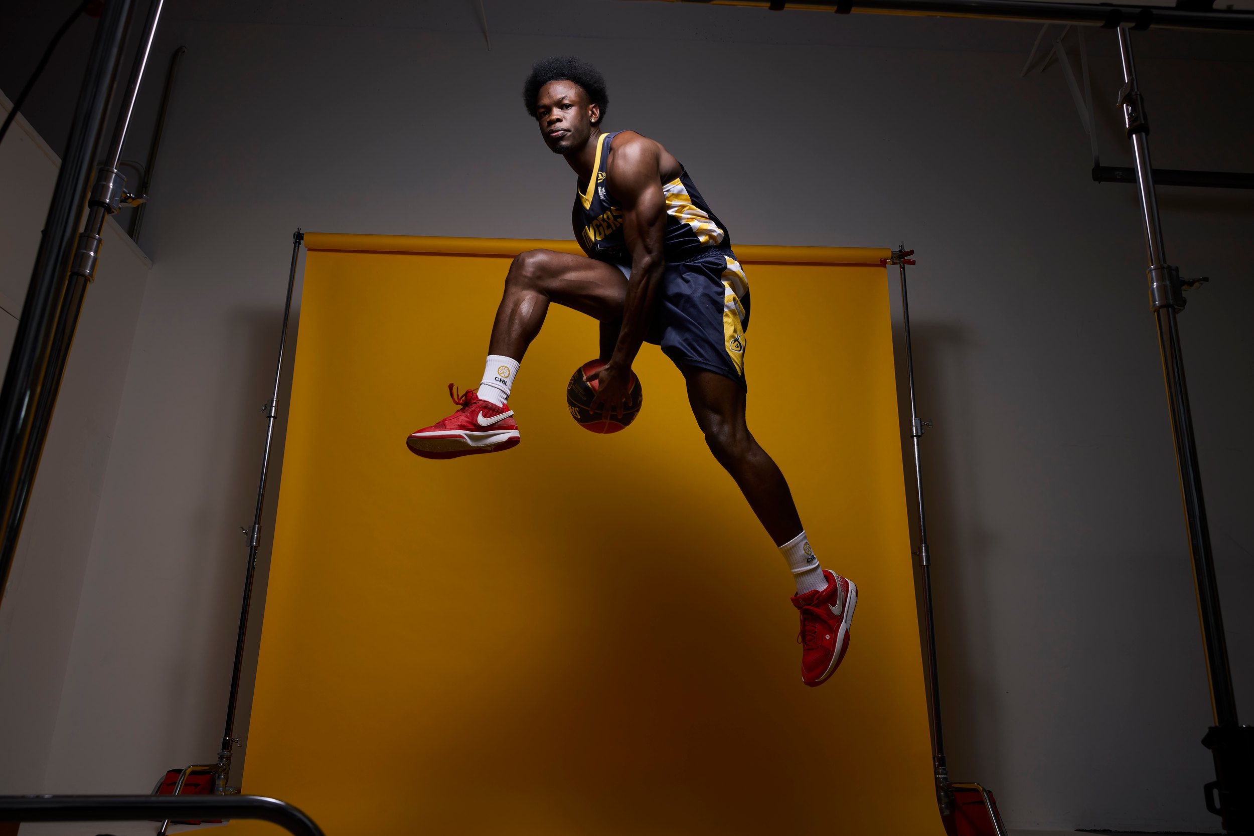 The frame the spread ran: Sabry Philip in the air above a yellow backdrop, the light stands and the studio around it