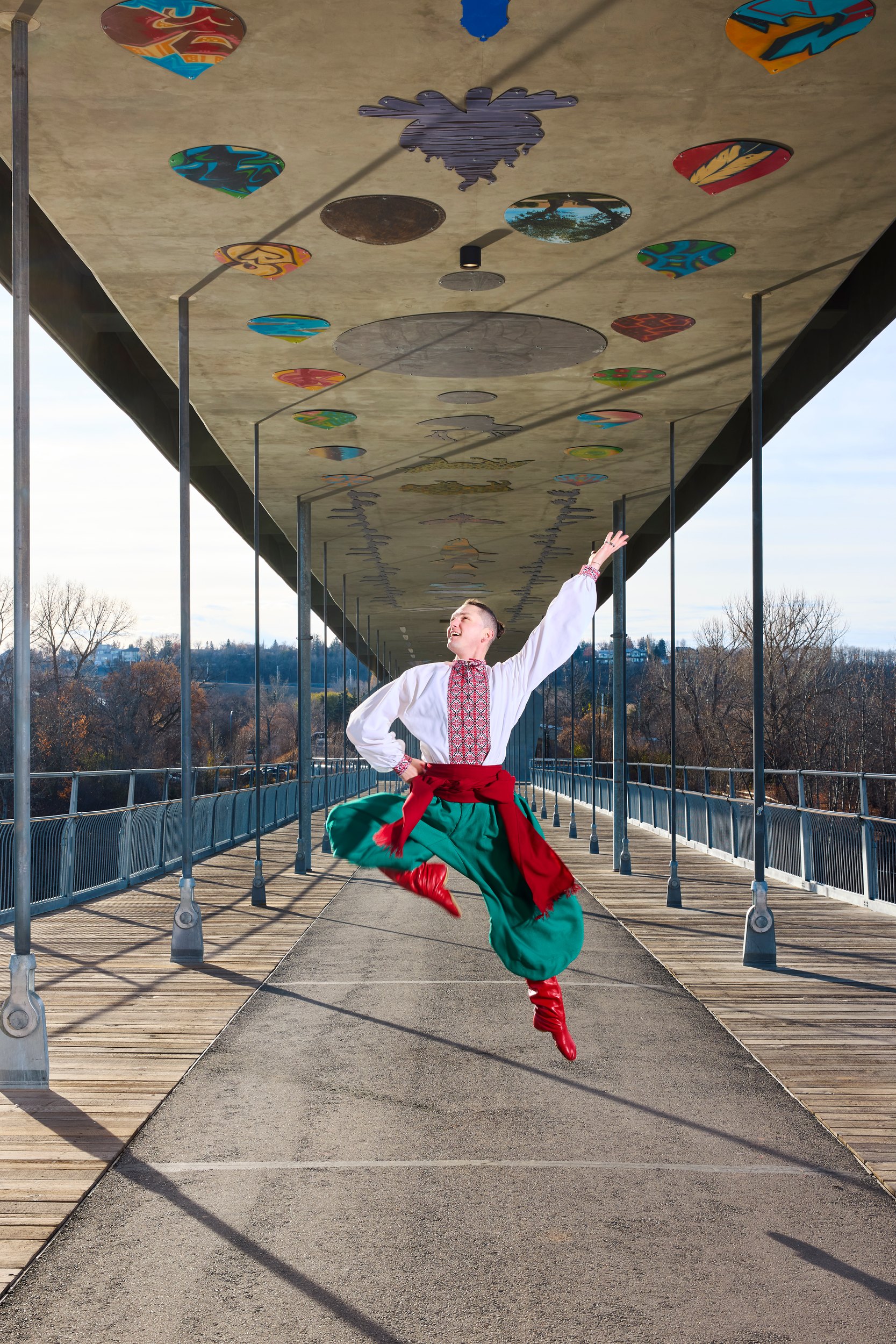 Mid leap, both arms out, the red sash swinging