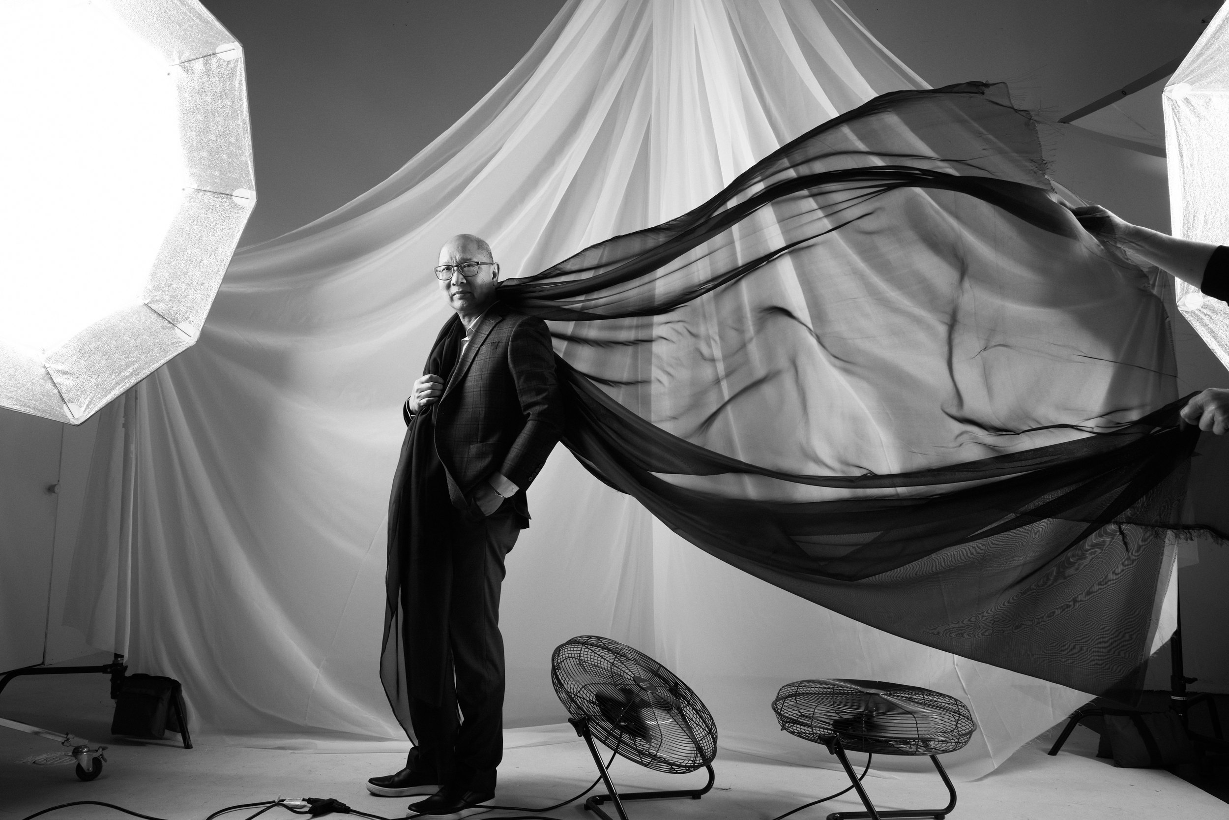 A man standing in a full sweep of cloth, arms wide