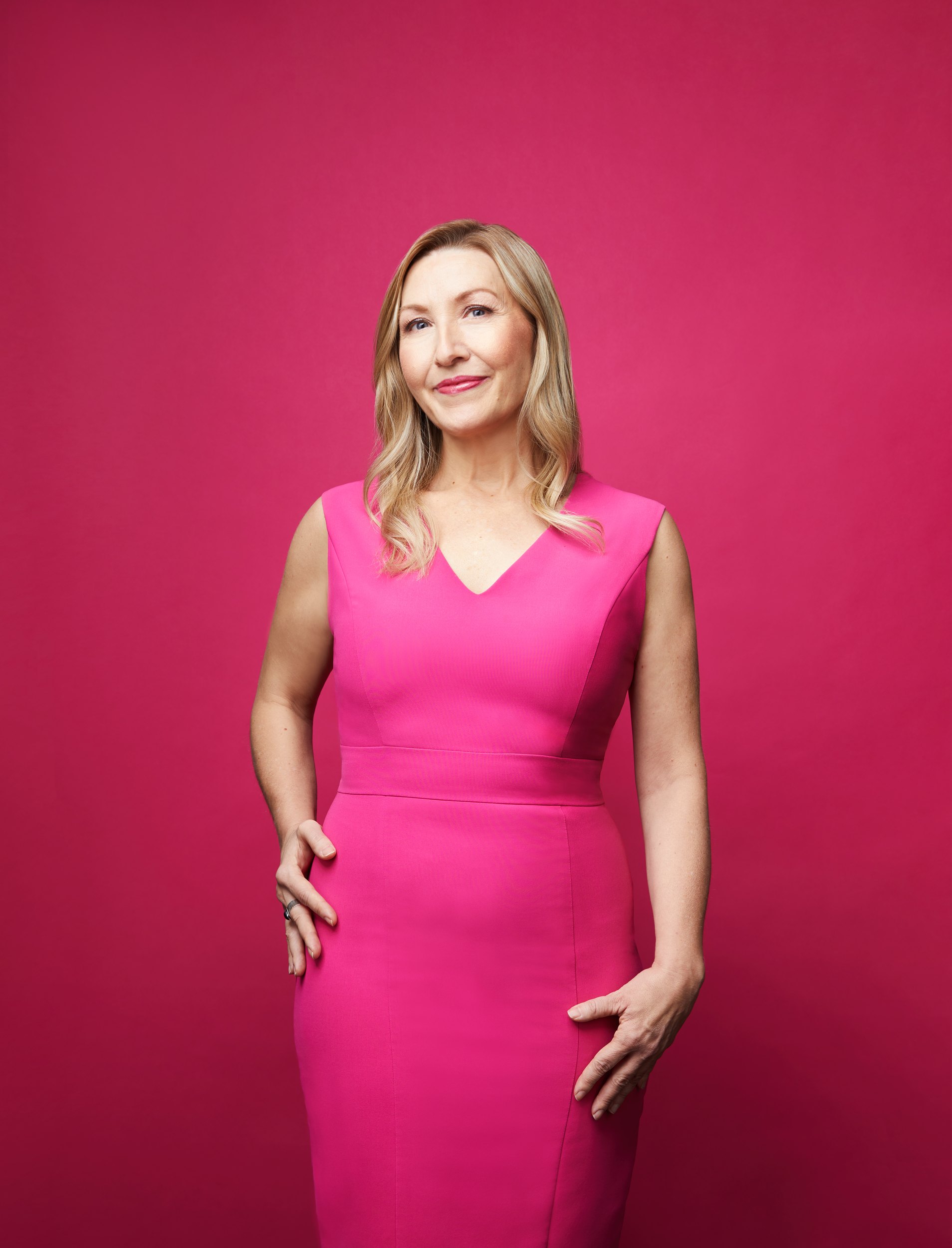Dr. Jana Rieger in a pink dress against pink, hands at her sides
