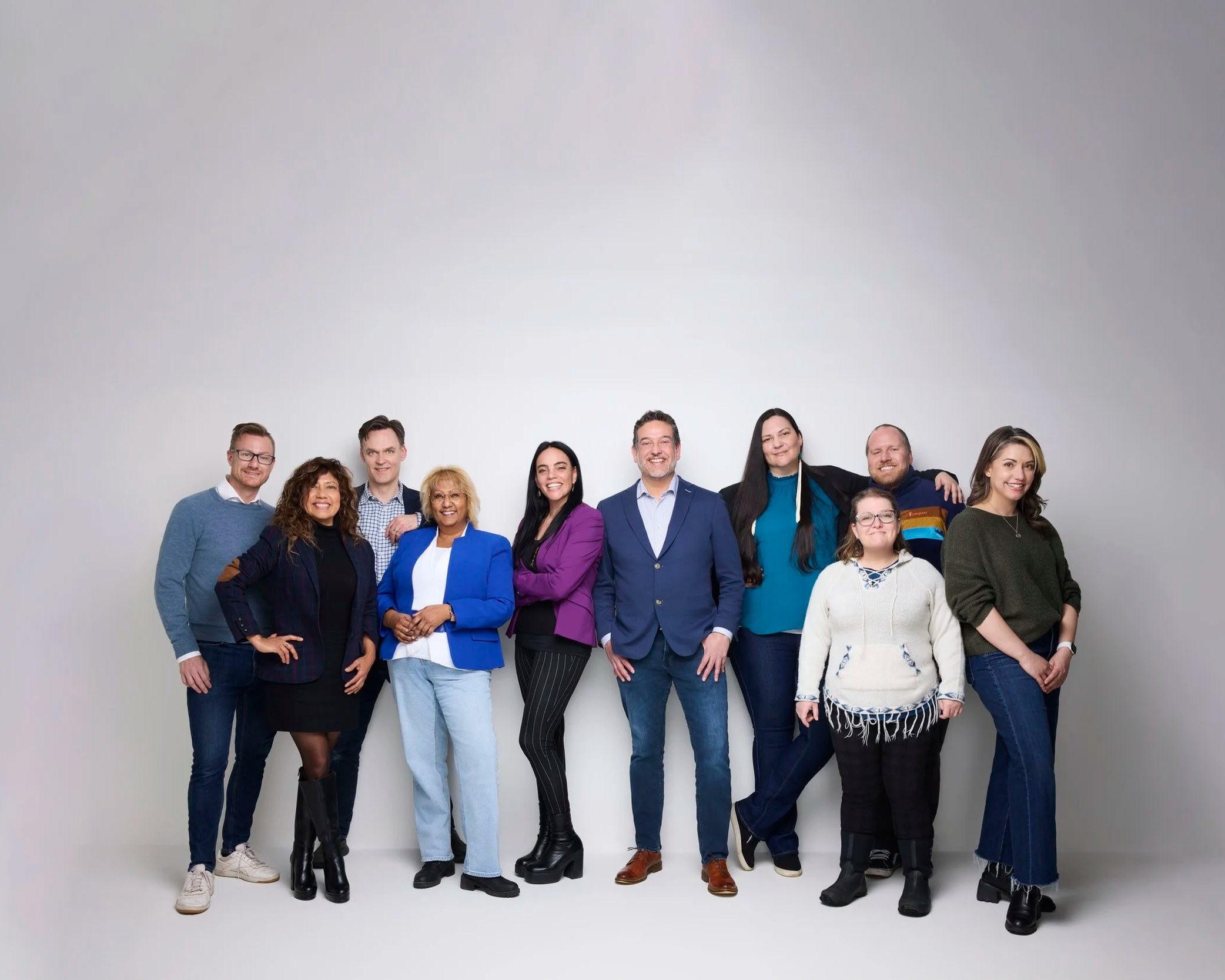 Group photo of a ten-person team on white, Edmonton studio