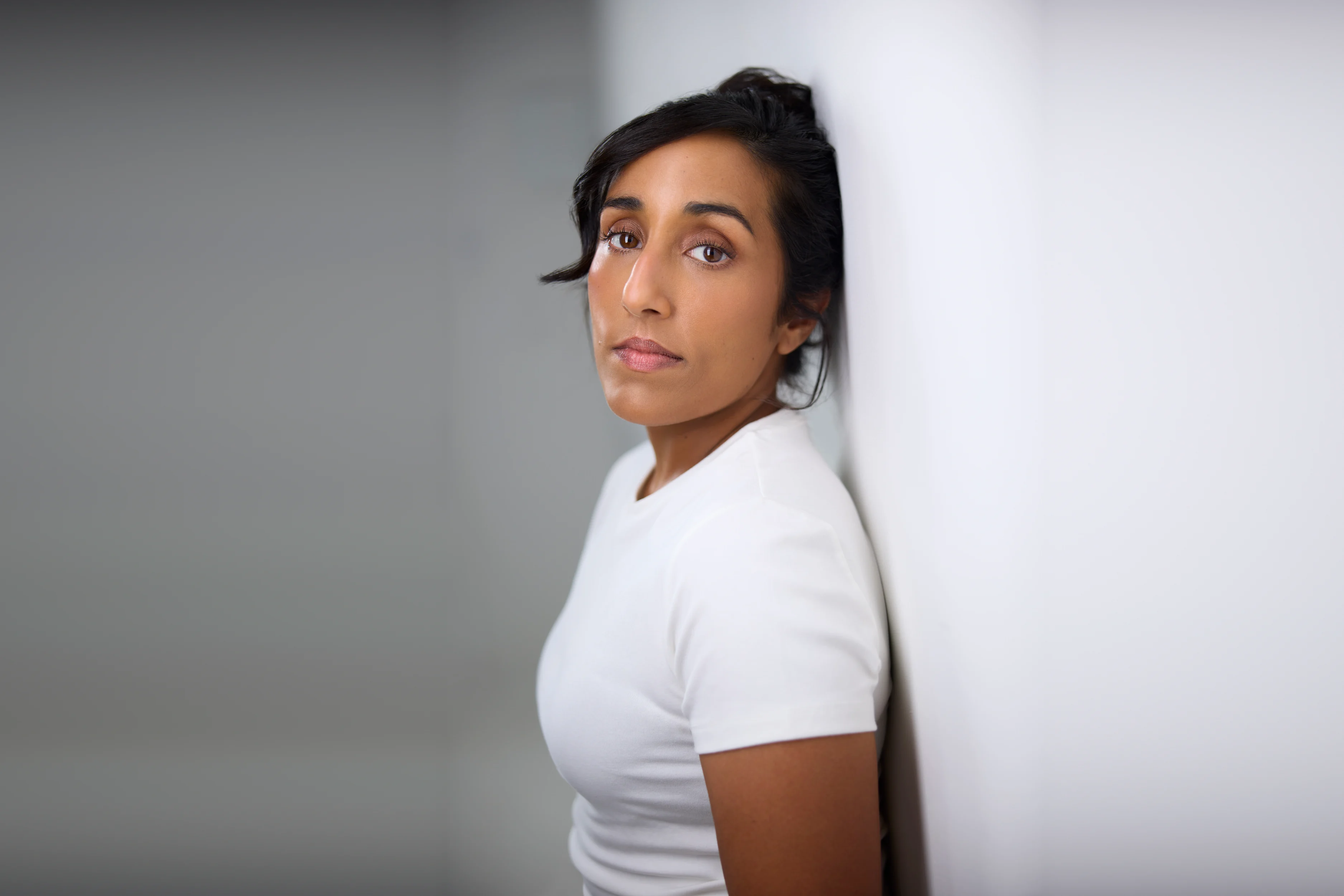 Ashley John against a white wall, actor headshot, Edmonton
