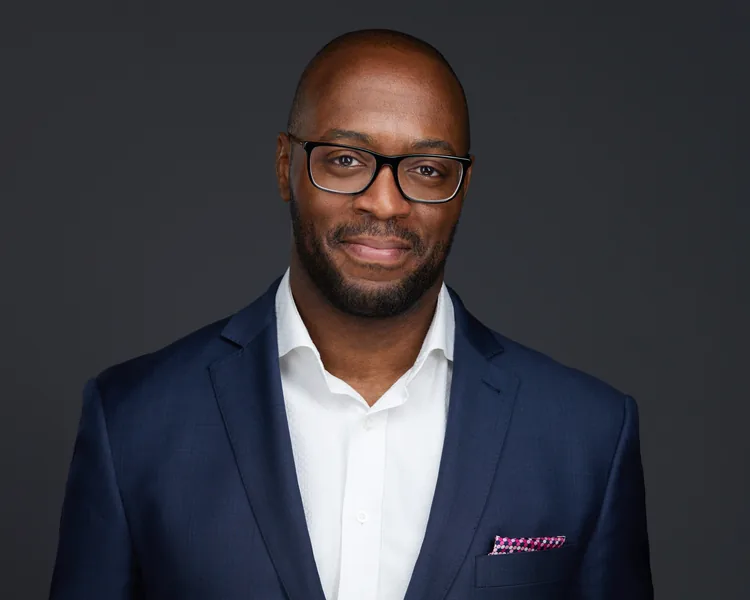 A tight corporate headshot on dark grey, Edmonton studio