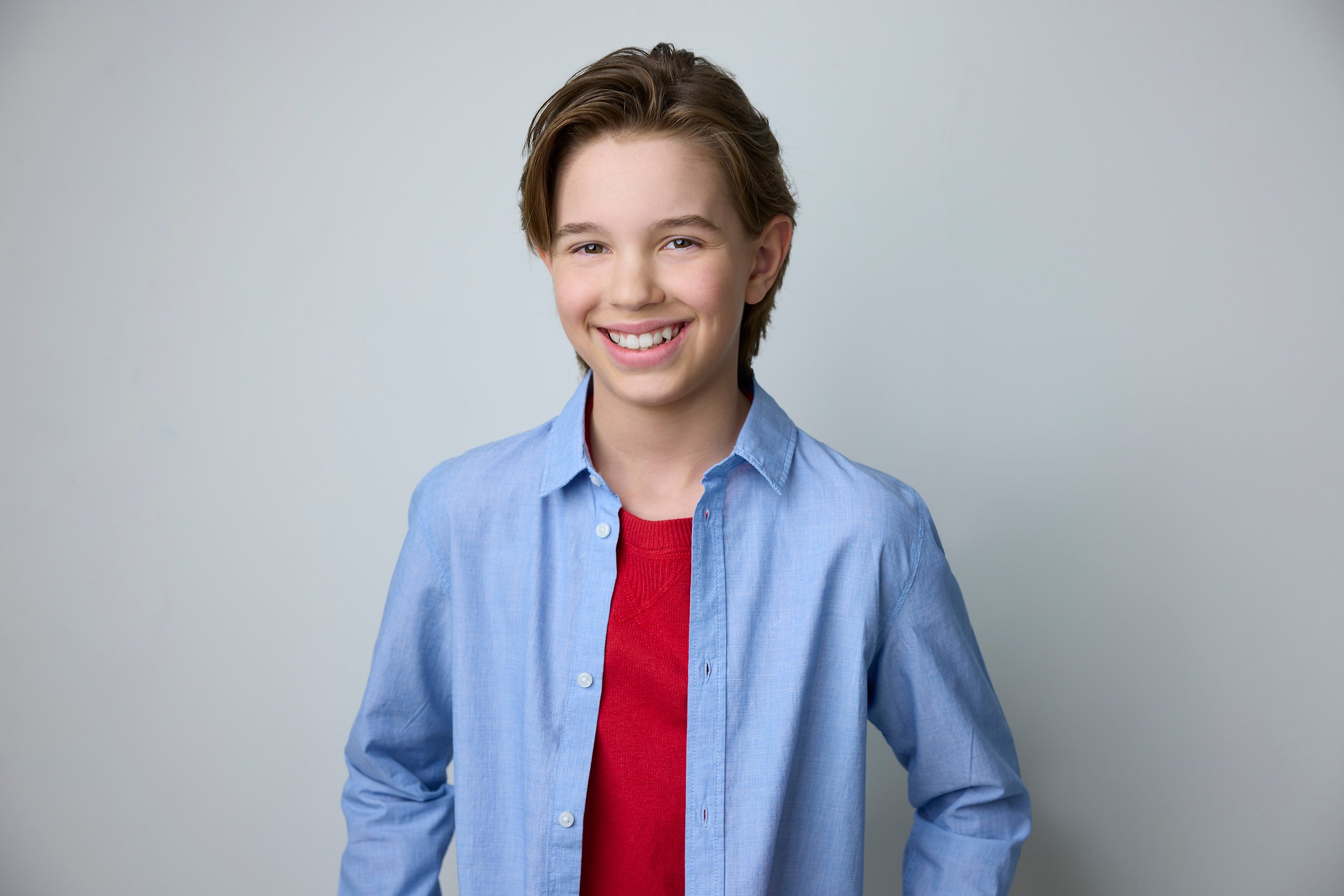 The same session, a blue shirt over red against white, smiling