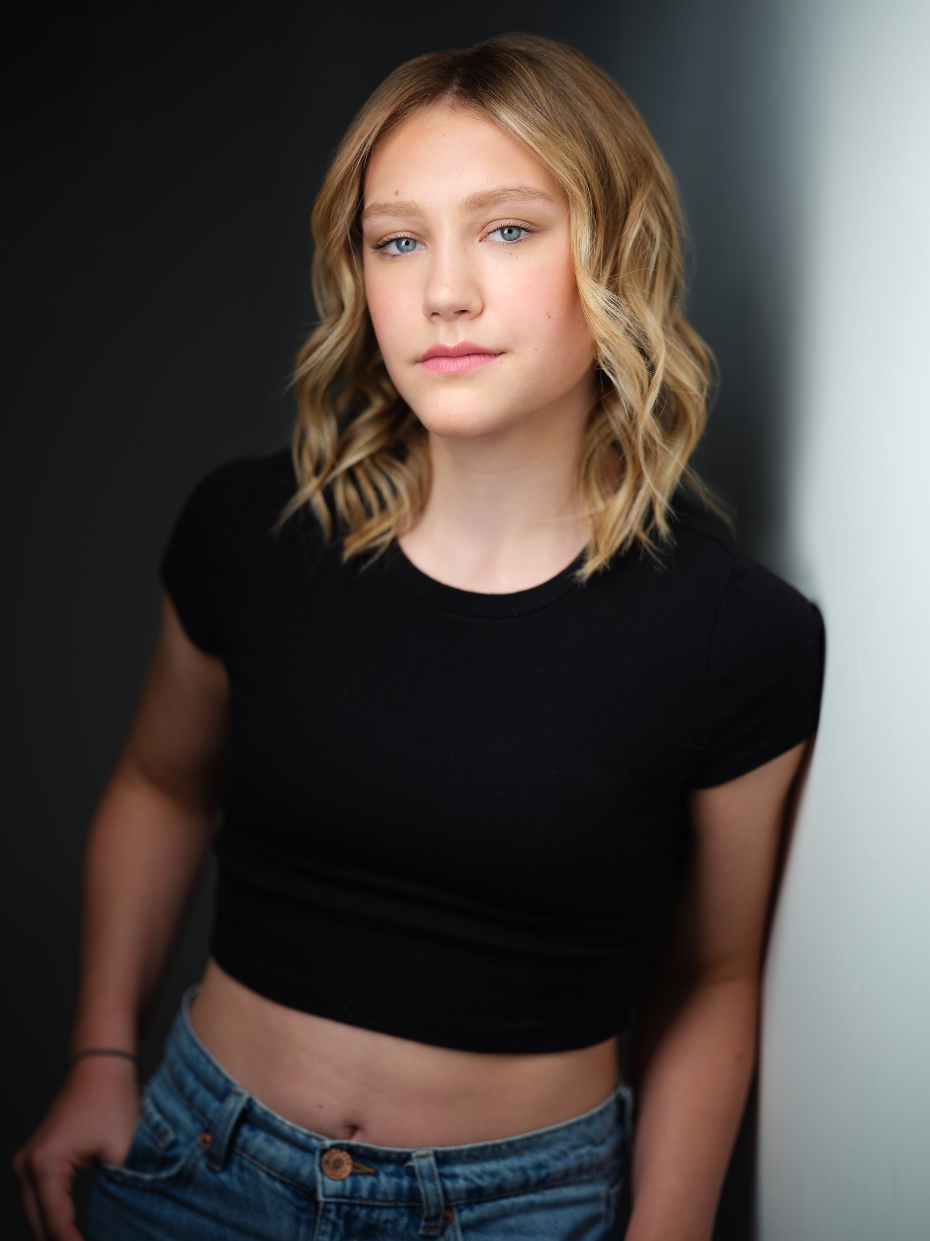 Kids and teens headshot: a black crop top and jeans against the wall of light