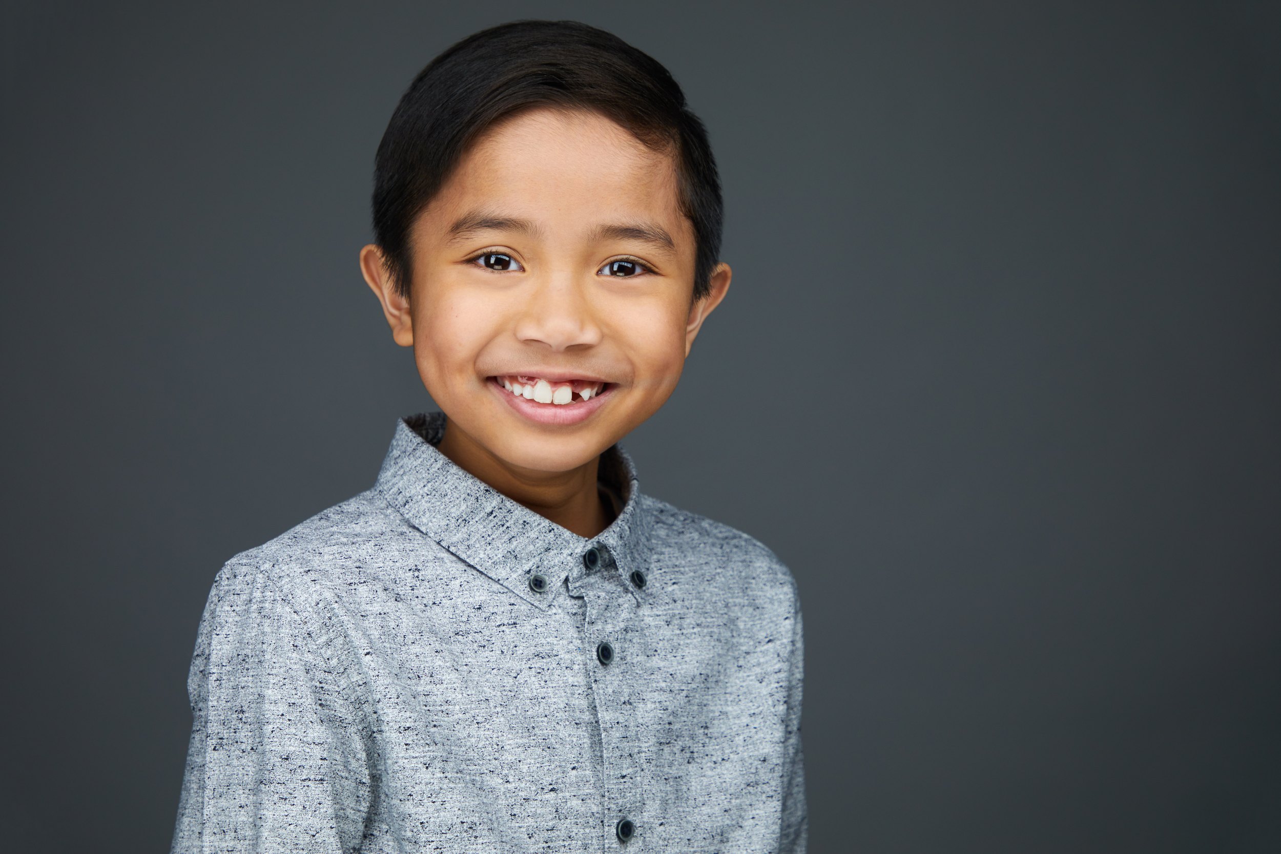 The same session, a speckled grey shirt against grey, grinning
