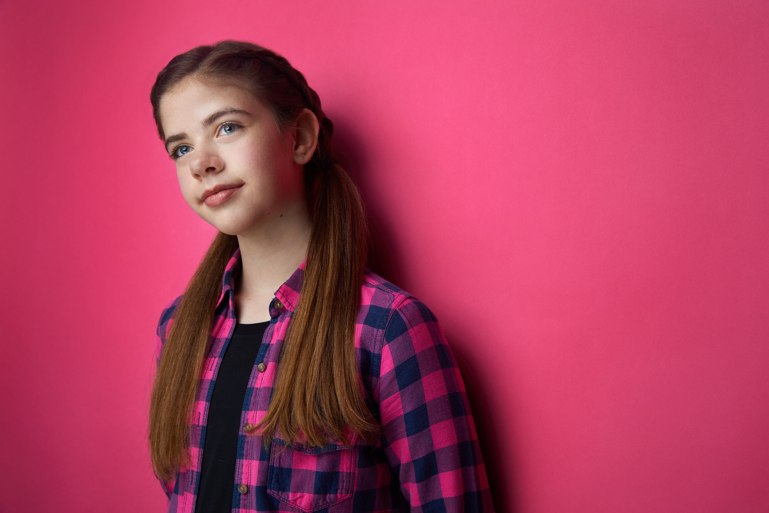 The same session, a pink and navy plaid shirt against hot pink, leaning