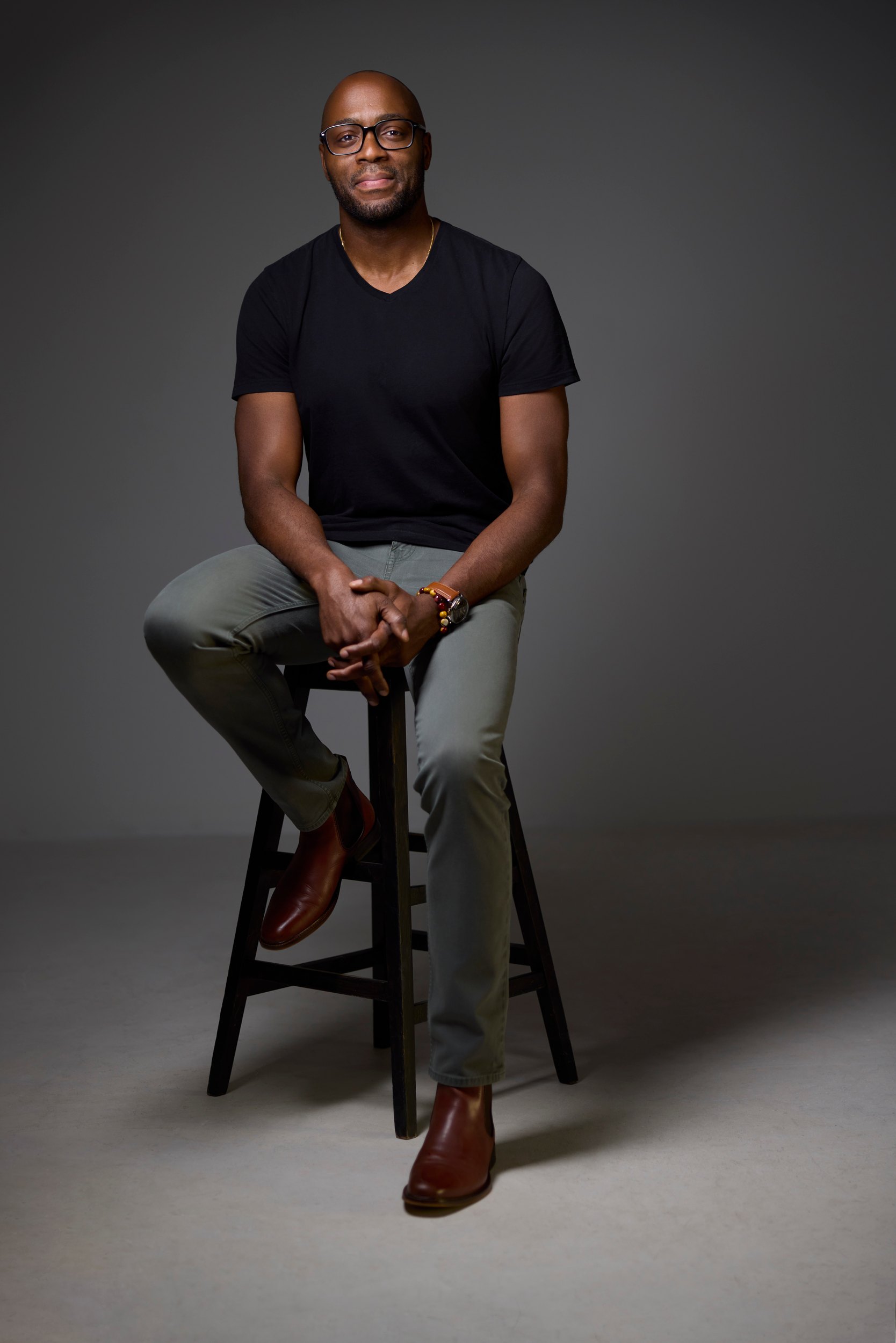 The same session: a black tee, seated