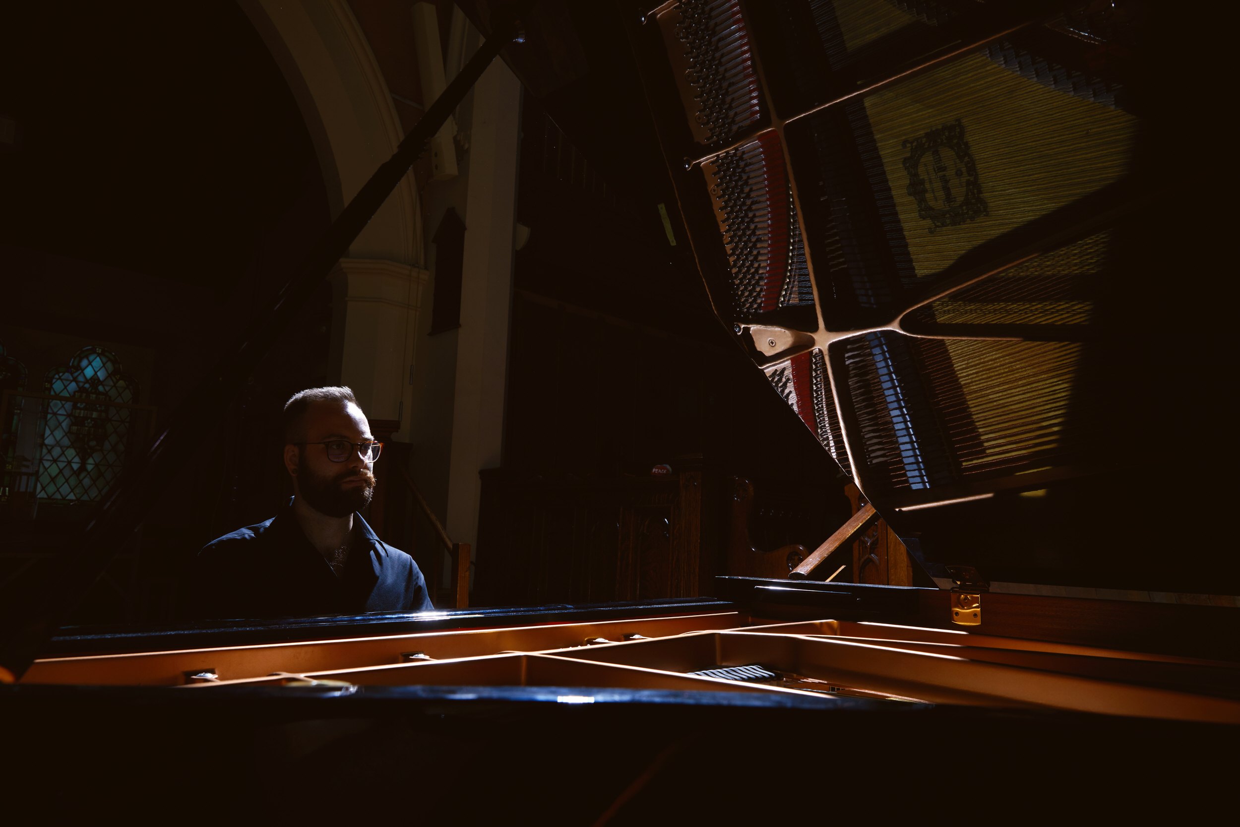 Personal branding portrait at a grand piano, low light