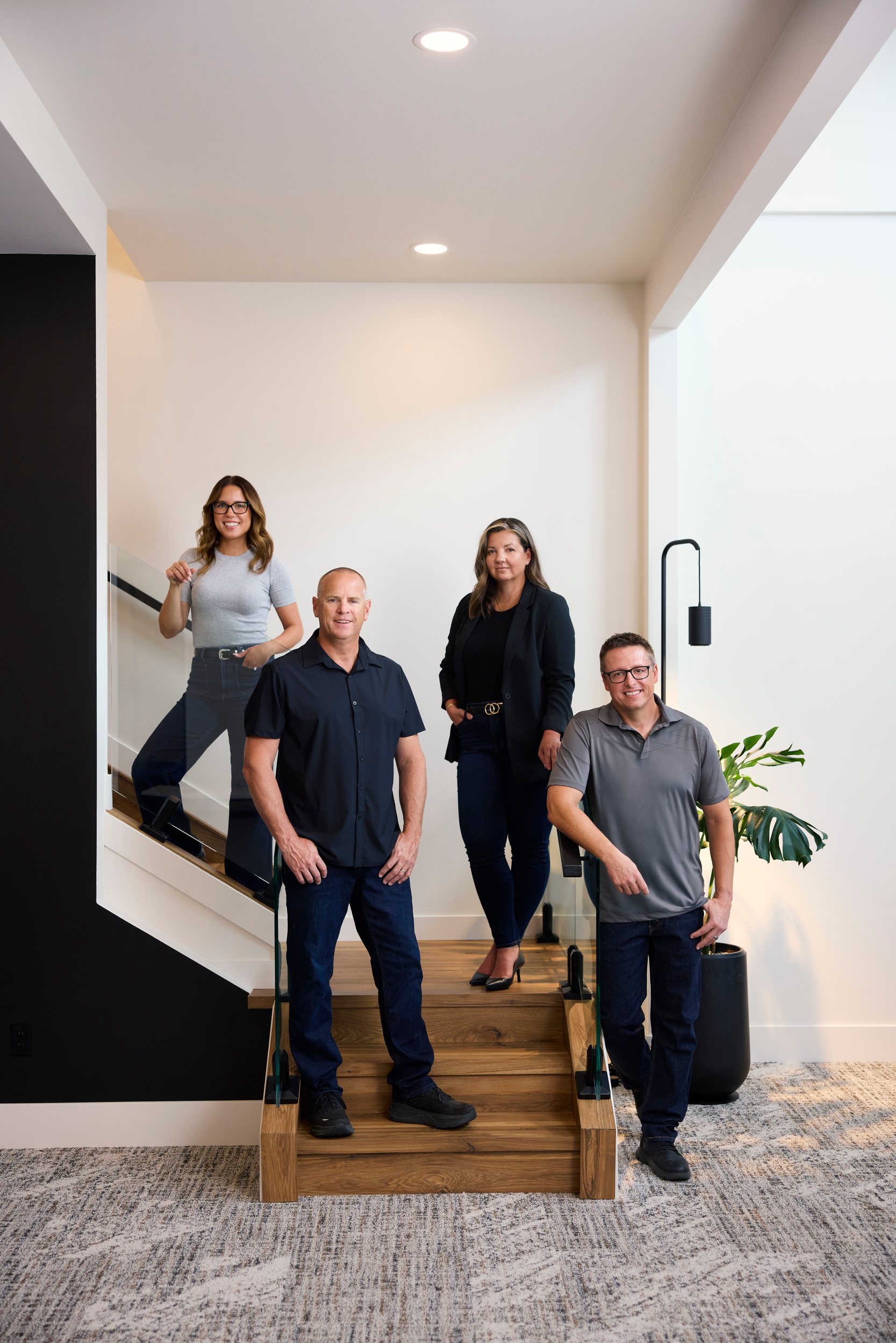 The same team on the open staircase of their bright, white office