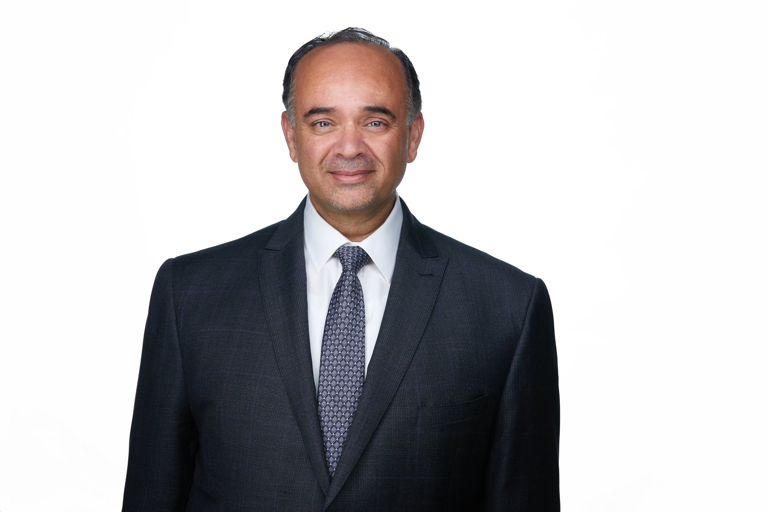 Real estate headshot: a charcoal suit and a patterned tie, on white