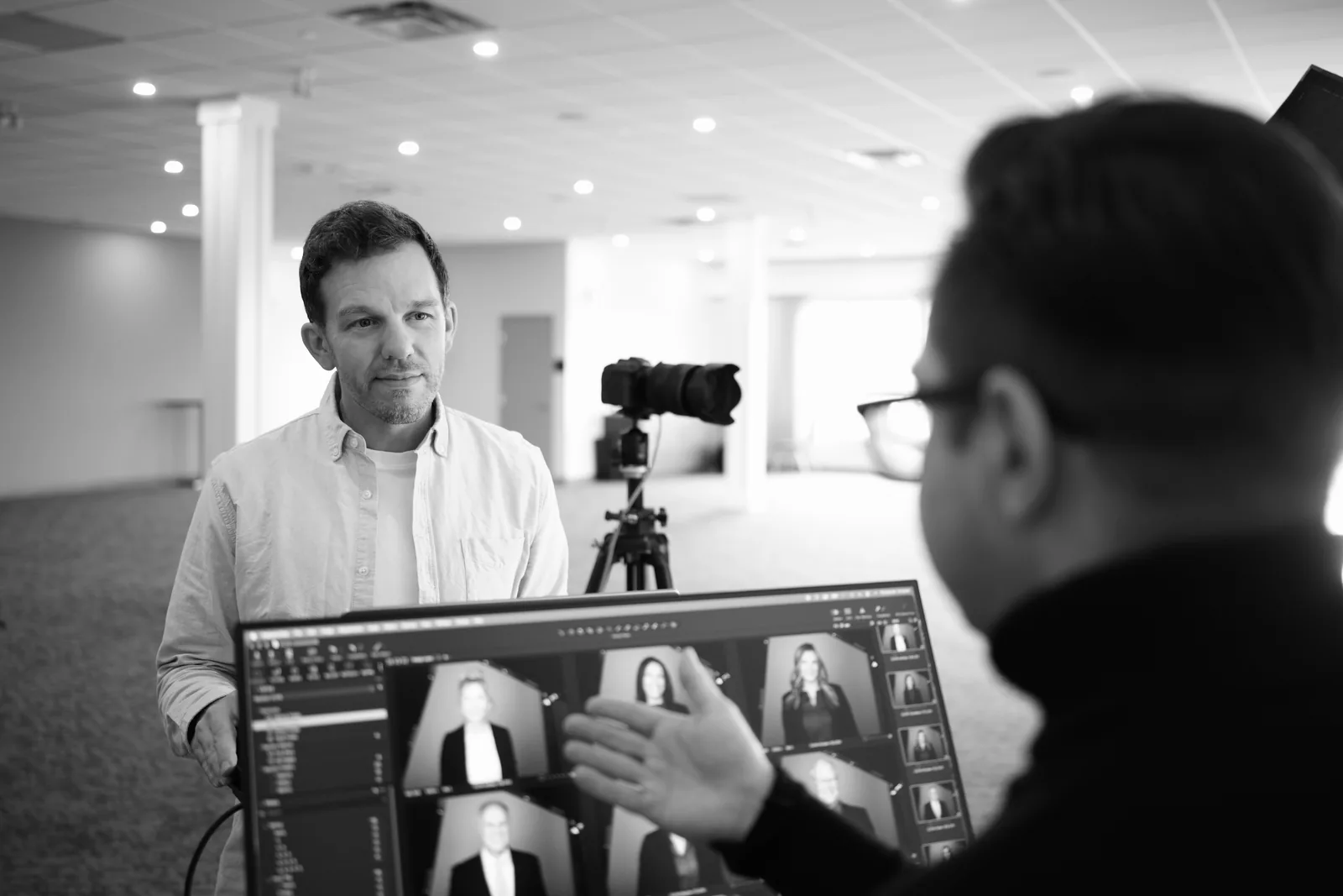 Ryan Parker and a client choosing headshots on the monitor during a team headshot day in Edmonton