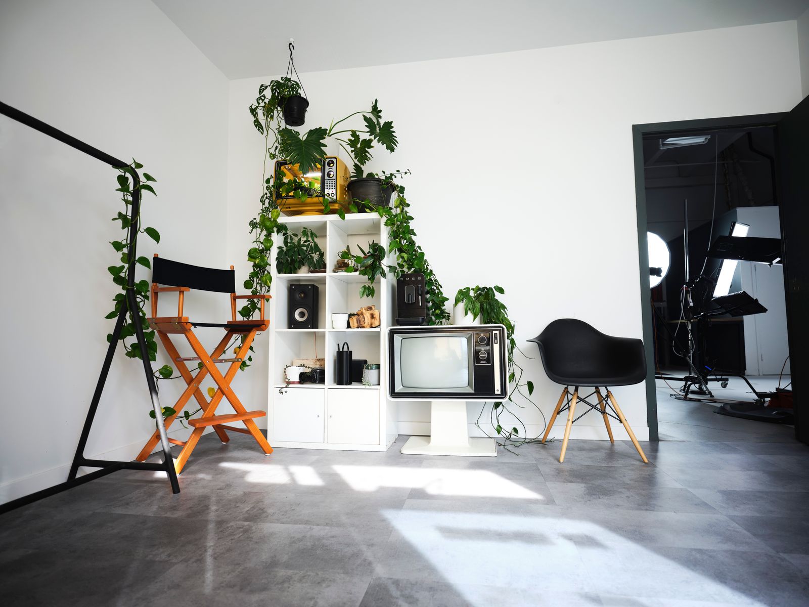 The studio front room — mirror, plants and the door through to the shooting space
